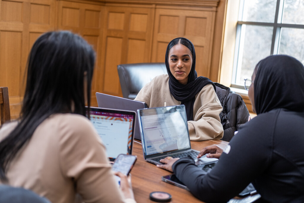 Three students sitting with laptops