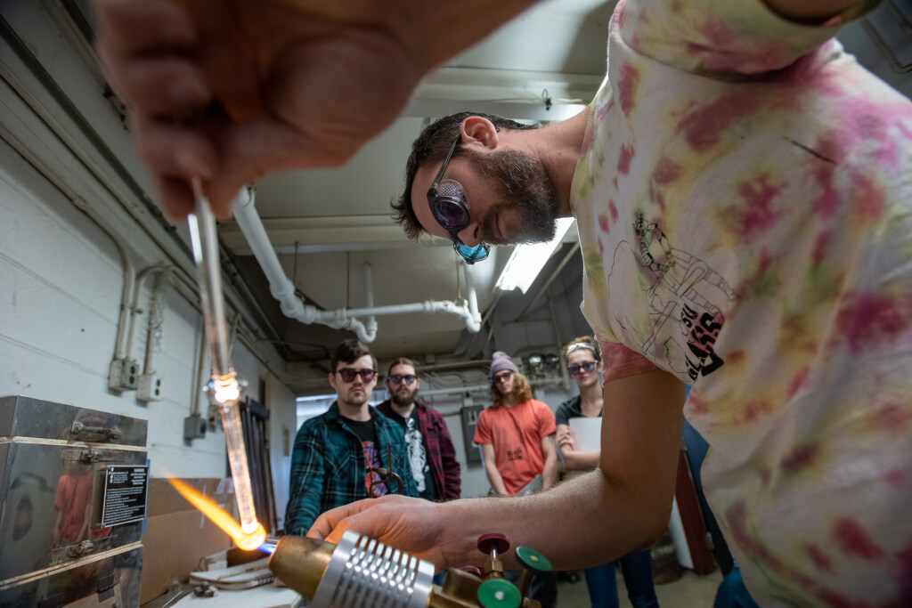 Student using a blow torch while four others watch