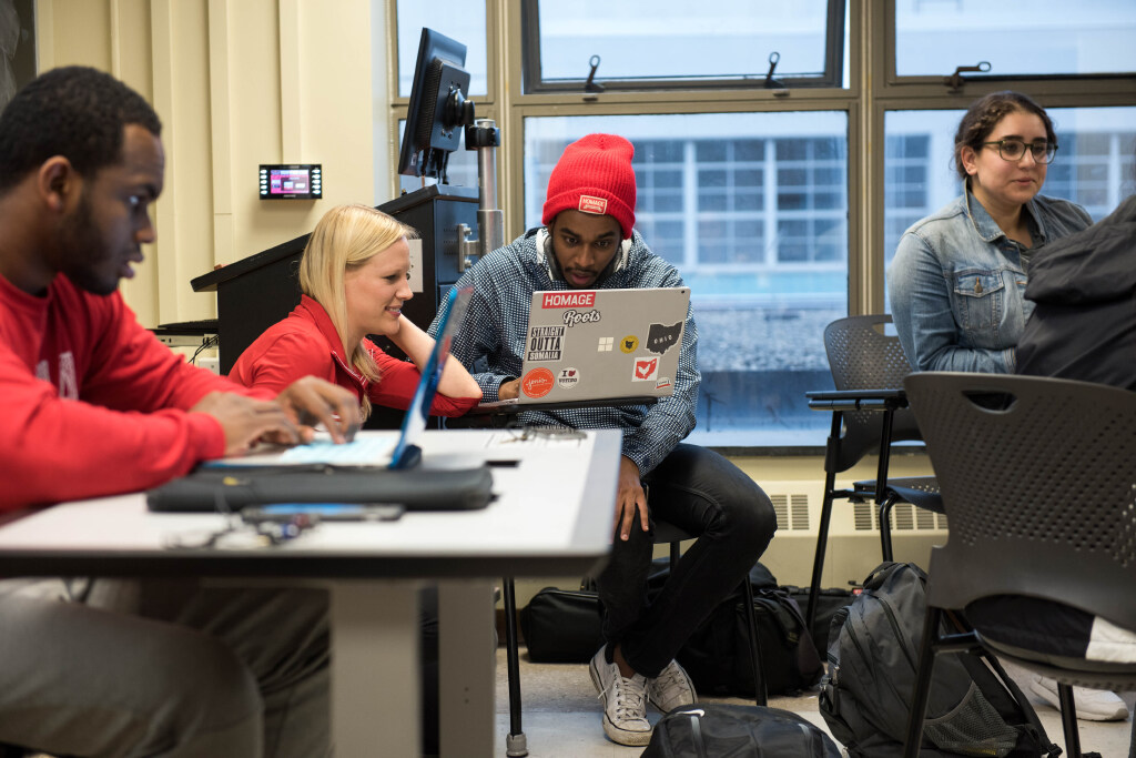 Four students working at laptops