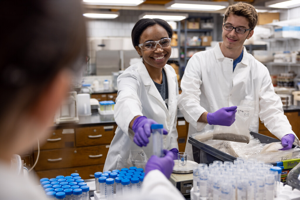 Person handing a student a test tube