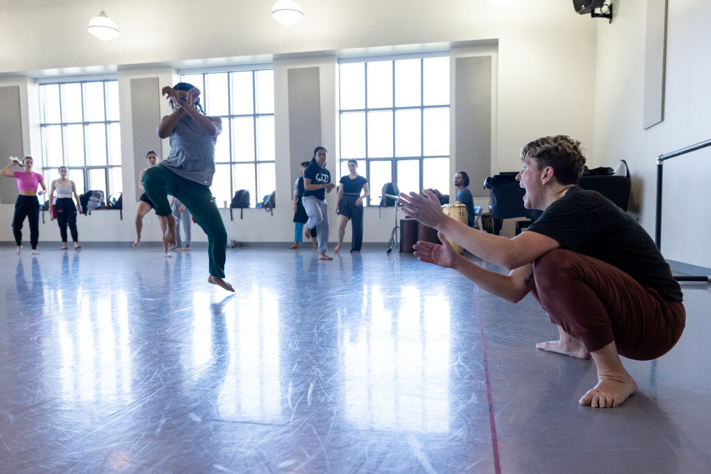 Students in a dance class rehearse indoors.