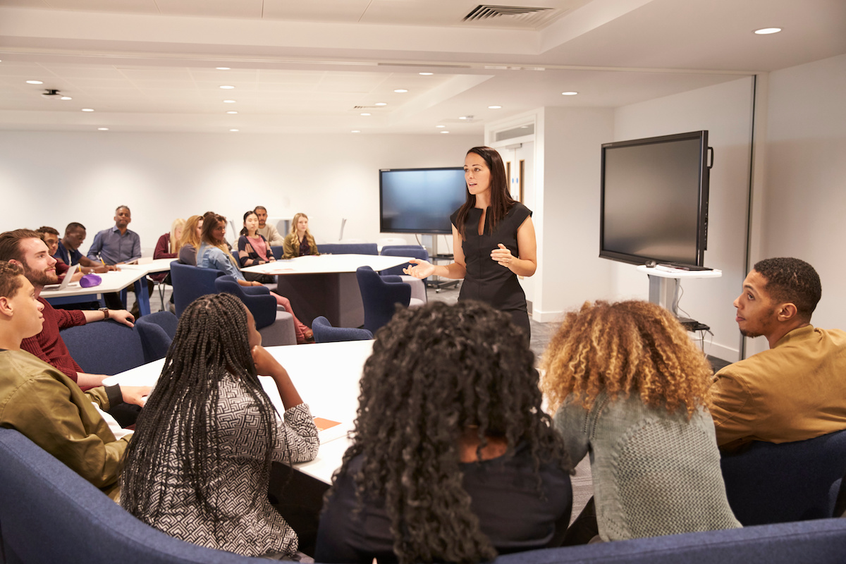 A faculty member lectures her students in a medium sized classroom.