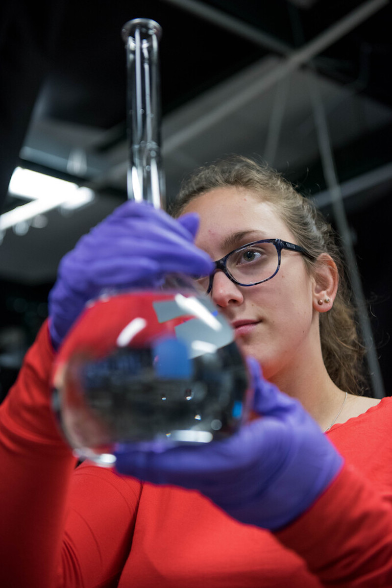 A young student holds a beaker.