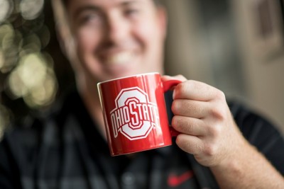 Image of an Ohio State mug being held with the smiling individual blurred in background