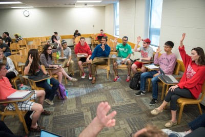 Image of a group of students in discussion with seats arranged in a large circle.