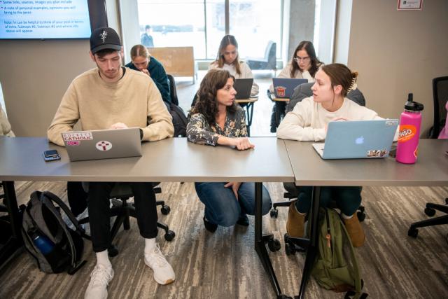 Students sit at desks facing forward in the classroom.