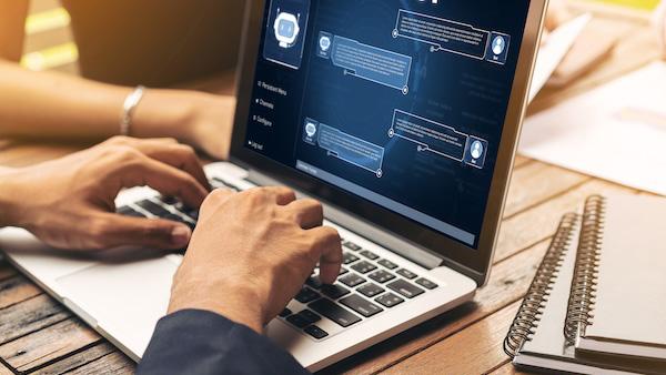 Hands type on a laptop with AI prompts and output shown onscreen