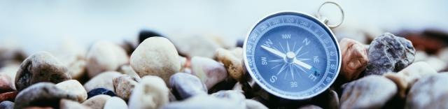 Compass on rocky surface.