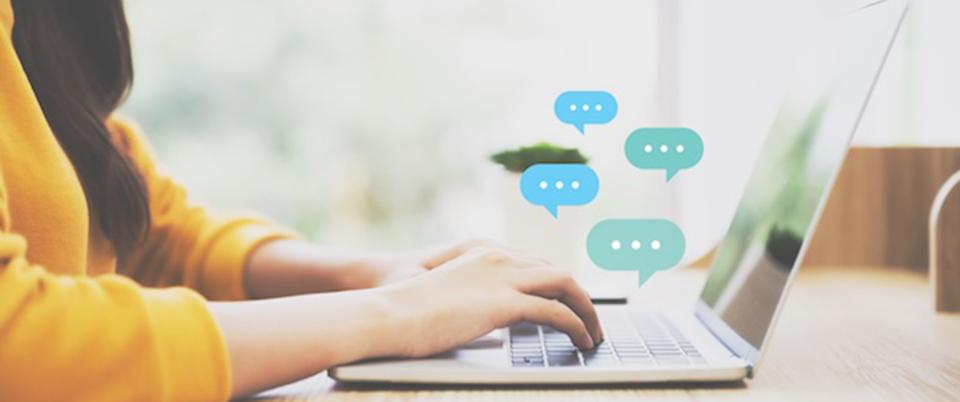 A person types on a laptop as conversation bubbles pop up.