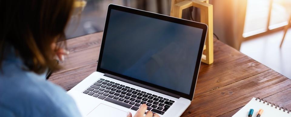 An instructor works at a laptop.