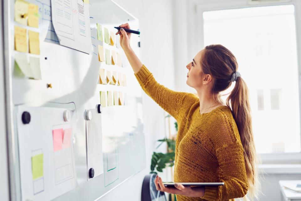 An instructor adds to a map of ideas on a whiteboard.