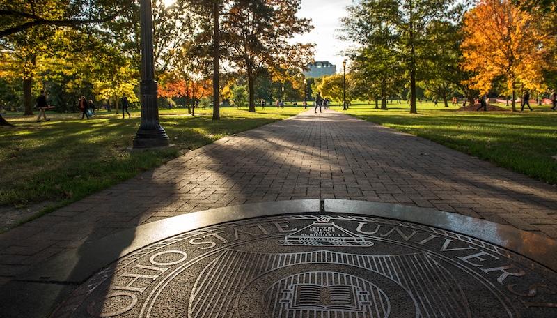 The oval seal on Ohio State's Columbus campus, with fall trees in the background.