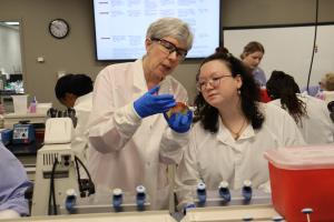 A clinical professor instructs two students.